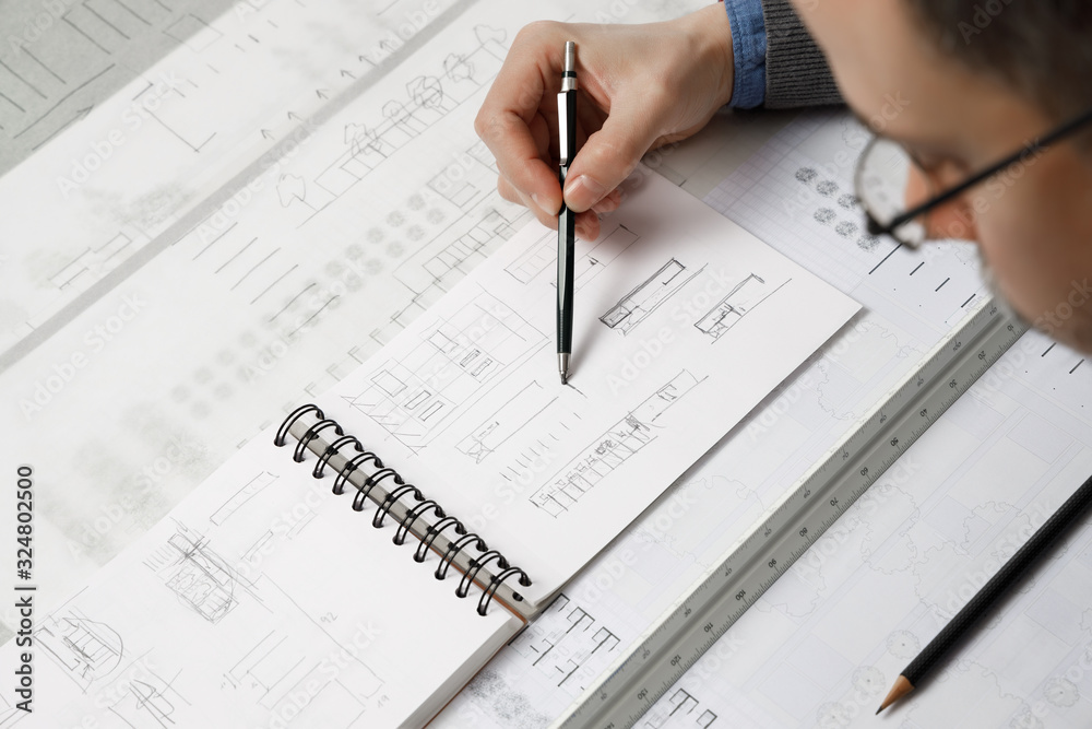 Architect hand drawing building plan sketch with mechanical pencil Architect hand drawing building plan sketch with mechanical pencil