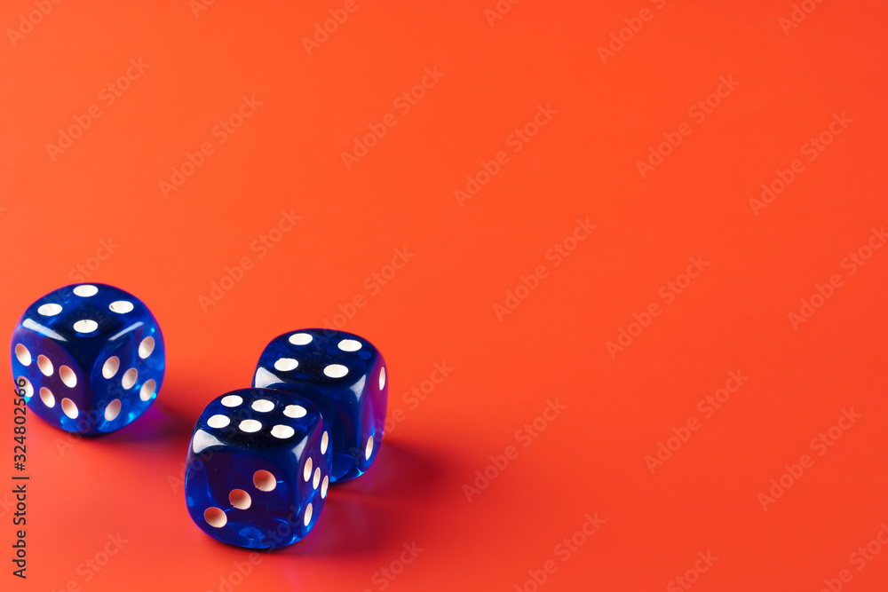 Blue dice on red background close up Blue dice on red background close up