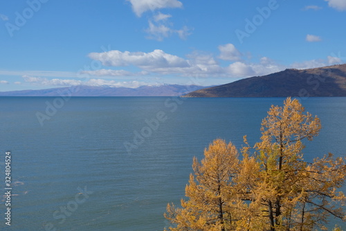 View on Markakol lake with mountains and cloudy sky  background. Mountain lake in autumn. photo