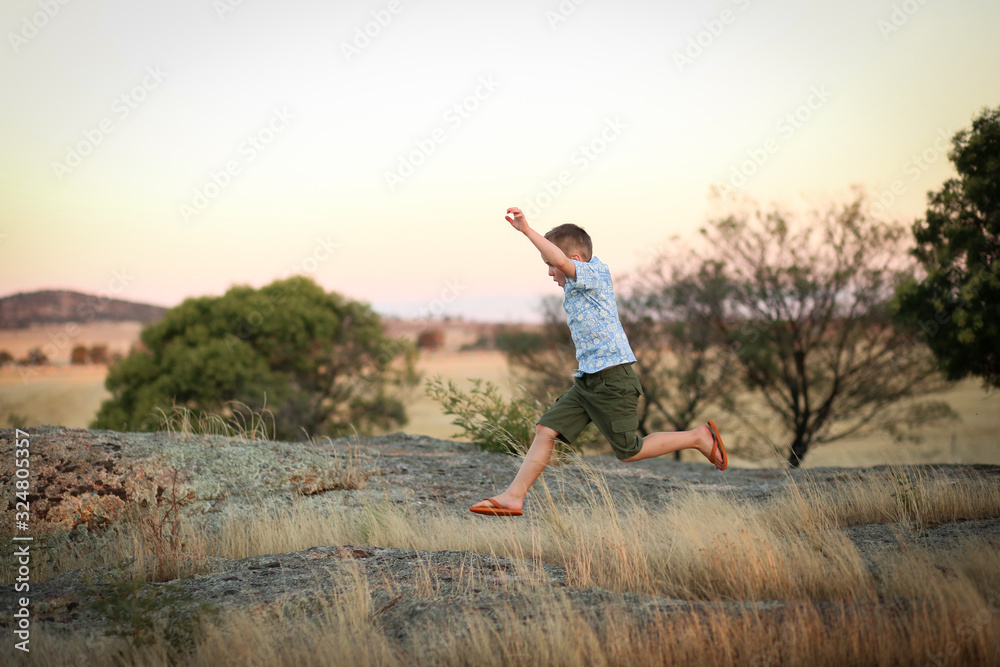 Child running and jumping on rock in natural setting Child running and jumping on rock in natural setting
