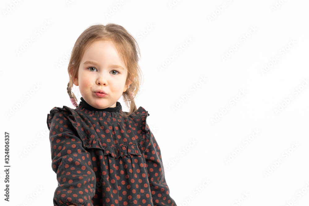 Waist up portrait of the confident redhead little girl in red pea dress that looking seriously at the camera isolated over white background Waist up portrait of the confident redhead little girl in red pea dress that looking seriously at the camera isolated over white background