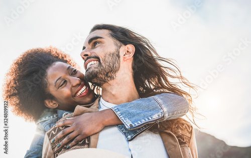 Multiracial couple having tender moments outdoor - Caucasian man and african woman having fun together during vacation - Travel, love and multi thnic relationship concept - Focun on man face photo