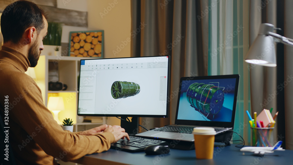Handsome engineer in his home office developing a new turbine Handsome engineer in his home office developing a new turbine