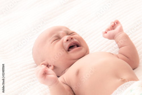 Newborn baby crying sick fever, get flu check up at clinic, Asian child infant 0-1month fussy screaming unhappy angry, hungry in bed at home, nursery young boy rough hard textile uncomfortable blanket
