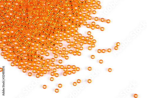 Orange beads scattered beads on a white background  top view  costume jewelry