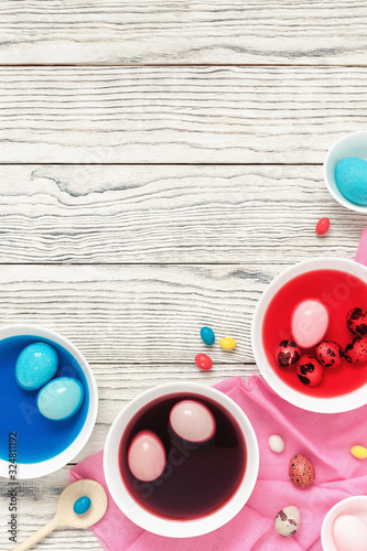Easter eggs dyeing in bowls with colors at home. Top view, flat lay, copy space