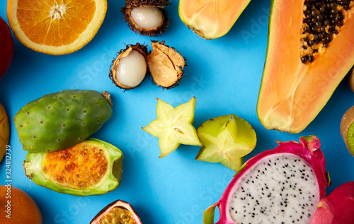 food  summer and healthy eating concept - different exotic fruits on blue background