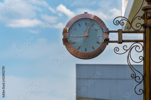 Street clock on sky background. Classic style streeet clock. photo