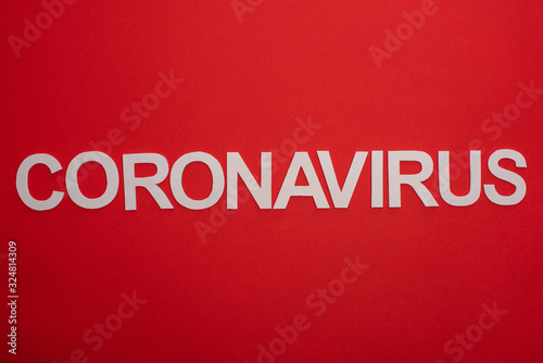Top view of coronavirus inscription isolated on red