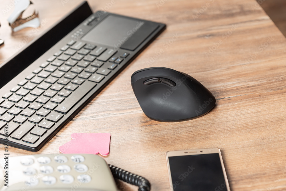 Office workspace with keyboard, phone and mouse on table Office workspace with keyboard, phone and mouse on table