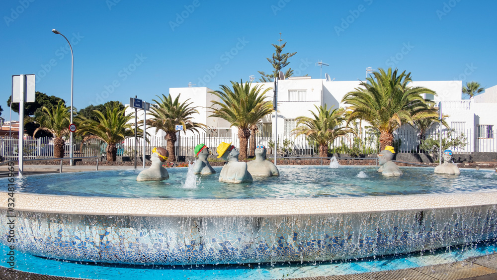 Fountain with tourists in a swimming pool, situated on the corner of the main road Avenida Jose Antonio Tavio and Calle Diana,  Costa del Silencio, Tenerife, Canary Islands, Spain
