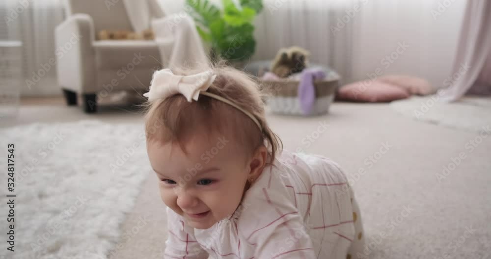 Baby girl crawling and learning to walking in the living room at home Baby girl crawling and learning to walking in the living room at home