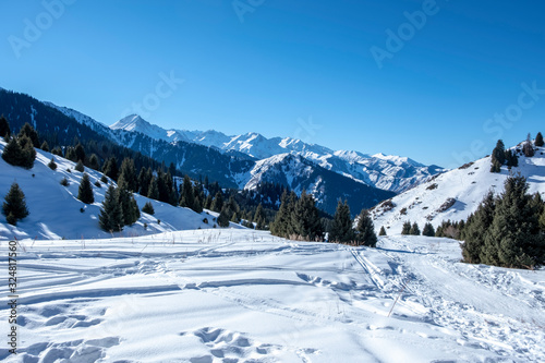 Trail in mountains in winter sunny day.