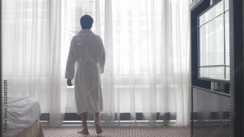 Young man in bathrobe admire view form the window in the morning. 4k Young man in bathrobe admire view form the window in the morning. 4k