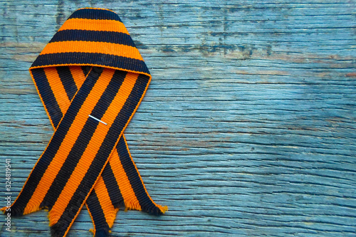St. George ribbon on a wooden background. Symbol of courage and victory, May 9 and February 23.