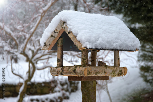 Bird feeder in winter covered with snow. Home made. Helping birds in winter