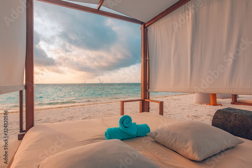 Fototapeta Naklejka Na Ścianę i Meble -  Sunset luxury beach canopy at tropical resort and spa for vacation. Wonderful scenery, white sand, sunset sky and relaxing mood. Perfect summer holiday, beach landscape, inspirational travel concept