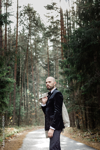 portrait of a middle-aged man in a business style in the forest © VetalStock