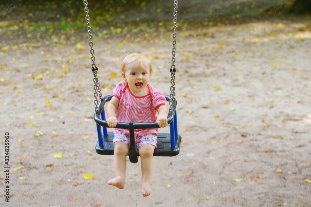 little baby happily rocks on the playground