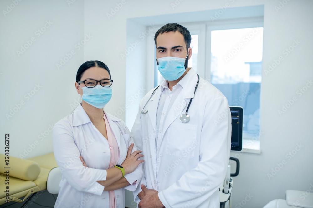 Male and female doctors wearing protective masks in the office Male and female doctors wearing protective masks in the office