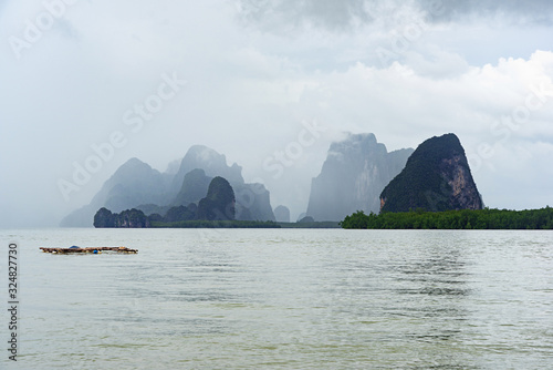 Limestone mountains on small island with mist and cloud