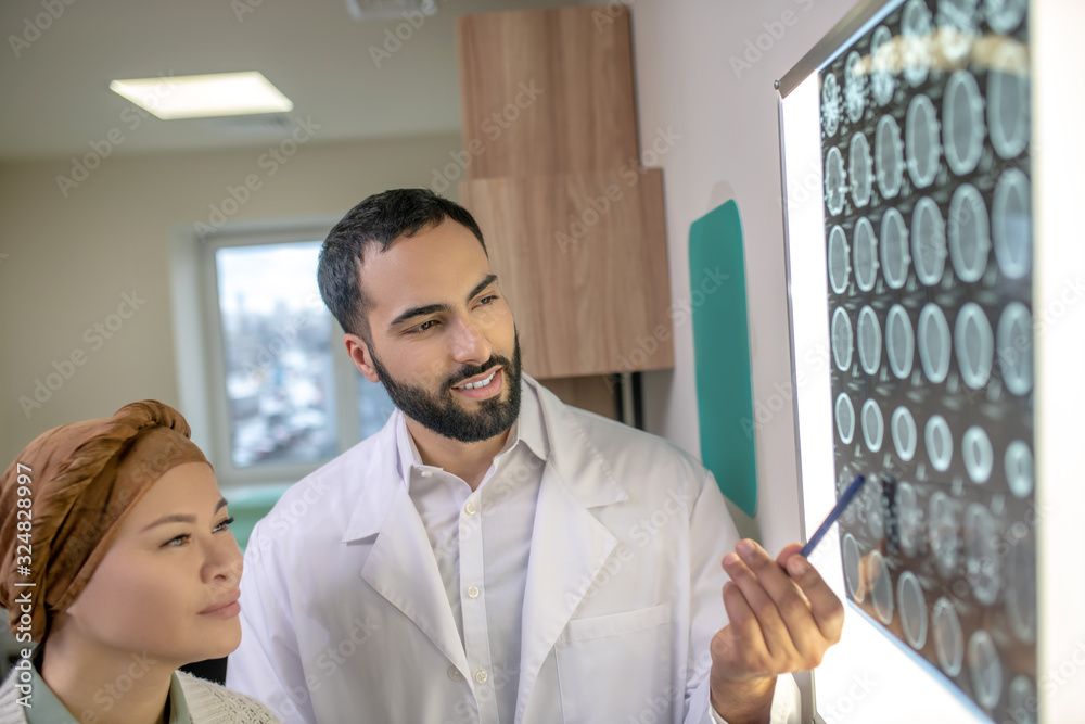 Fototapeta premium Bearded young doctor explaining MRI results to the patient