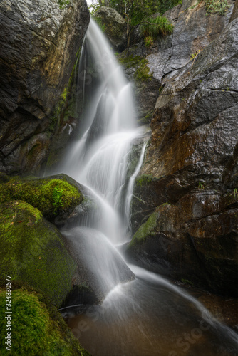 Water Stream collapses among Huge Mossy Granite Rocks