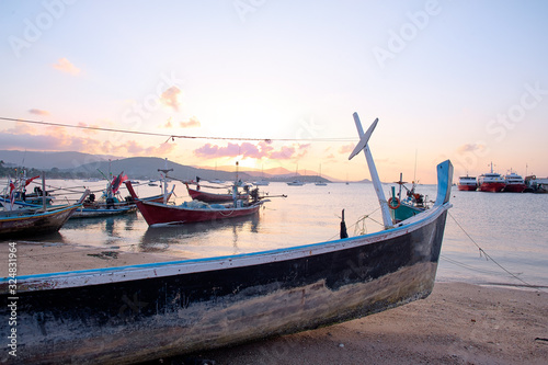Beautiful sunset on the sea with traditional thai fishing longtail boat.s