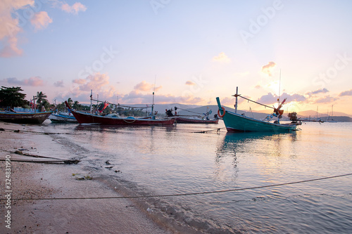 Beautiful sunset on the sea with traditional thai fishing longtail boat.s photo