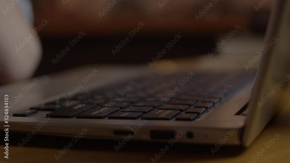 Young man working with laptop at loft apartment, close up, slow motion. Clicking enter button Young man working with laptop at loft apartment, close up, slow motion. Clicking enter button