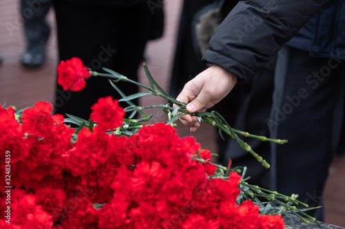 lay red carnations flowers at the memorial. tribute to those killed in the war