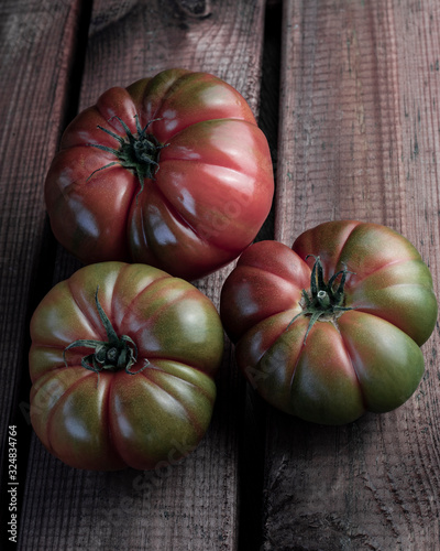 fotografias de tomate moruno comida ecologica tonos verdosos y rojizos en un fondo de madera iluminacion baja photo