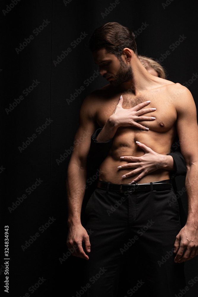 young woman touching sexy man isolated on black young woman touching sexy man isolated on black