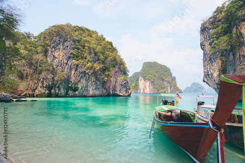 Beautiful landscape with traditional longtail boats, rocks, cliffs, tropical beach. Krabi, Thailand.