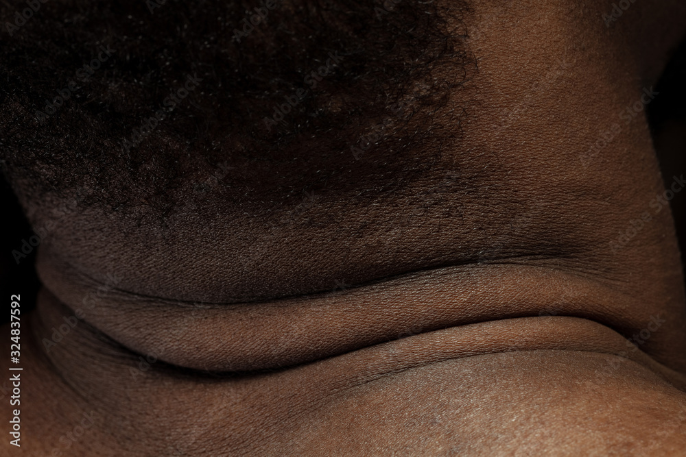 Fototapeta premium Head, neck. Detailed texture of human skin. Close up shot of young african-american male body. Skincare, bodycare, healthcare, hygiene and medicine concept. Looks beauty and well-kept. Dermatology.