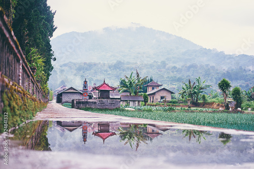 After the rain. Beautiful landscape with traditional balinesse houses, field and mountain. photo