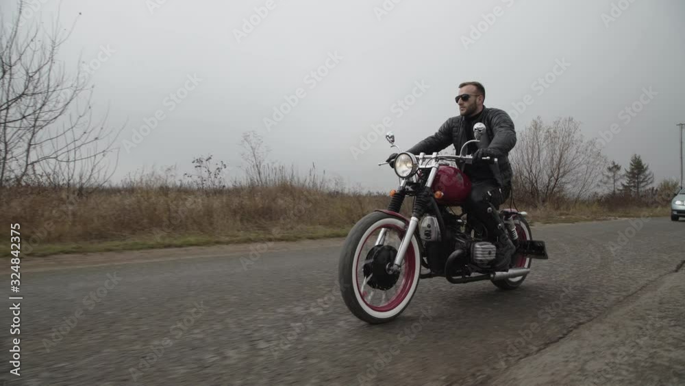 View of handsome biker riding on highway out of city View of handsome biker riding on highway out of city