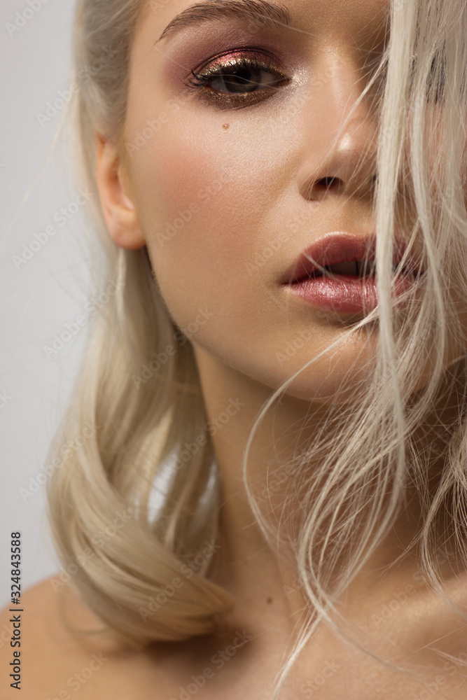 Close-up portrait of the beautiful woman with dark smoky eye makeup, natural pumpy lips and shiny liner. Sexy model with clean skin, long curly hair. Soft care, glamorous image Close-up portrait of the beautiful woman with dark smoky eye makeup, natural pumpy lips and shiny liner. Sexy model with clean skin, long curly hair. Soft care, glamorous image