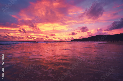 Beautiful sunset on ocean beach. Sky is reflecting at water. © luengo_ua