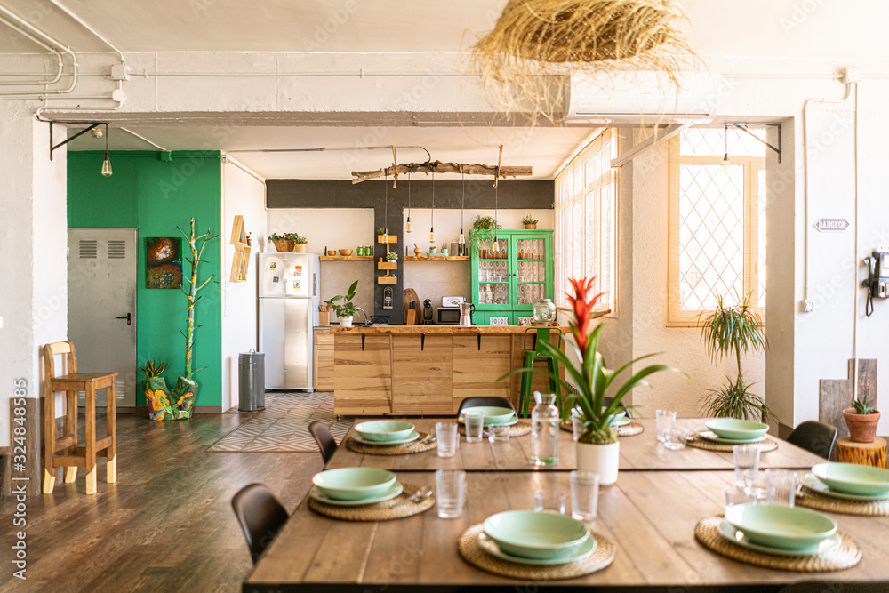 Interior design / decoration. Spacious open kitchen and dining room in bright industrial loft, with table set ready for a nice meal. - obrazy, fototapety, plakaty 
