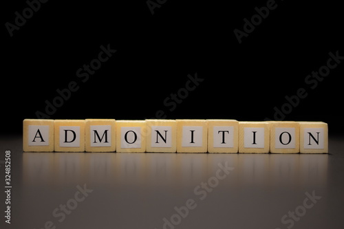 Fotografie The word ADMONITION written on wooden cubes isolated on a black background