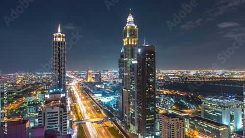 Scenic Dubai downtown architecture night timelapse. Top view over Sheikh Zayed road with illuminated skyscrapers and traffic.