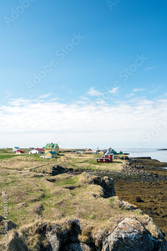 Colorful buildings and the charming city of Flatey Island in Iceland just outside Stykkisholmur and the Westfjords. Blue sky and sunny weather. Vertical shot photo