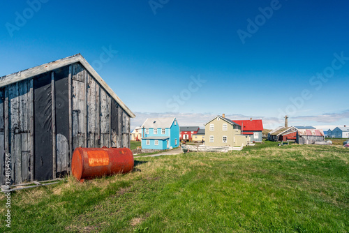 Colorful buildings and the charming city of Flatey Island in Iceland just outside Stykkisholmur and the Westfjords. Blue sky and sunny weather. Explore and traveling concept. photo