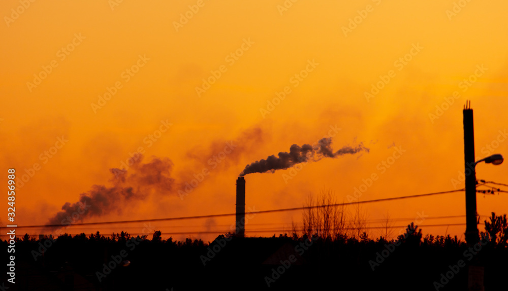 Silhouette of an industrial factory on a sunset background
