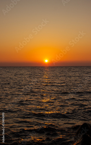 beautiful Sunny sunset on the sea. Amazing summer view on the beach.  blazing sunset landscape at black sea and orange sky above it with awesome sun golden reflection on calm waves.