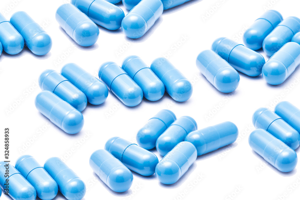 Blue capsules isolated on white. Medicine healthcare background. Drugs dose in group. Painkiller pills pile. Pharmacy virus cure. Empty copy space medicament in group backdrop. Blue capsules isolated on white. Medicine healthcare background. Drugs dose in group. Painkiller pills pile. Pharmacy virus cure. Empty copy space medicament in group backdrop.