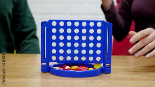 Two players playing a Connect Four game. Connect Four is a two player game first introduced in 1974 by Milton Bradley. photo