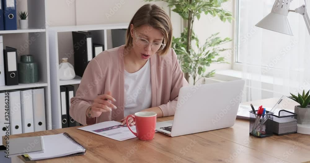 Businesswoman working on office laptop and writing notes Businesswoman working on office laptop and writing notes