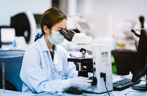 medical technician look at the microscope  in medical laboratory